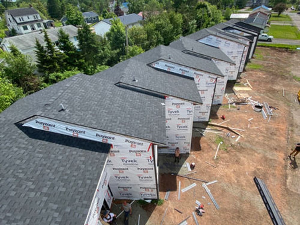 Newly built homes under construction with Tyvek sheathing and asphalt shingles.